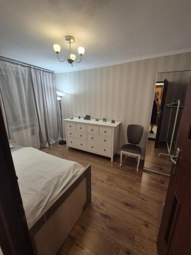 a bedroom with a bed and a dresser and a mirror at Mały pokój przy lotnisku in Poznań