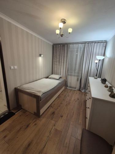 a small bedroom with a bed and a desk at Mały pokój przy lotnisku in Poznań