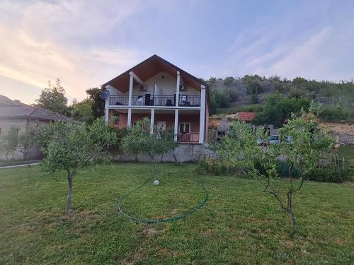 a house with a hose in a yard with trees at Zrmanja Riverside Oasis in Bilišane