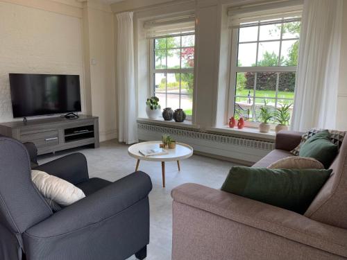 a living room with two couches and a tv at Huis van alle winden in Ovezande