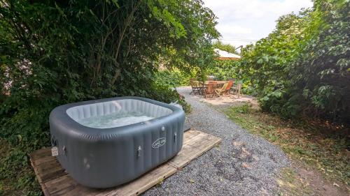 a hot tub sitting on a wooden platform in a yard at Gîte Ferme de la Chevêche & Jacuzzi Namur in Sart-Saint-Laurent
