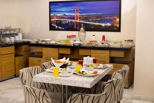 een eetkamer met een tafel met eten erop bij Vizyon Hotel - Old City in Istanbul