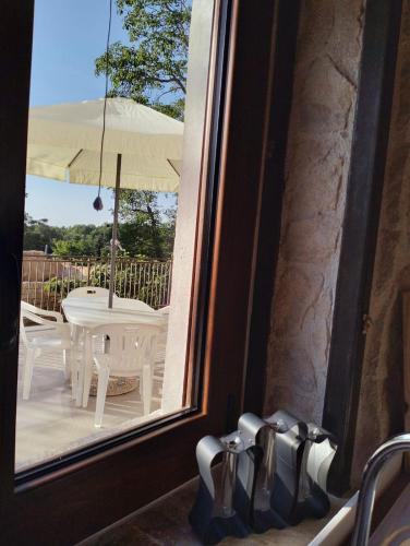 a view of a table and an umbrella from a window at Casa Rurale Pietra Bianca in Roccamorice
