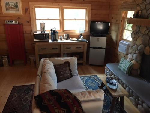 a living room with a couch and a kitchen at Apple Valley Cabin in Sonora