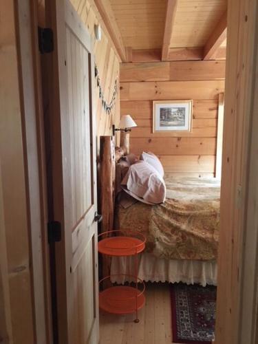 a small bedroom with a bed in a wooden cabin at Apple Valley Cabin in Sonora