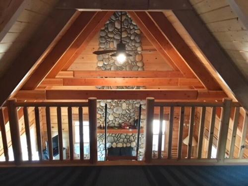 a wooden staircase with a window in a attic at Apple Valley Cabin in Sonora