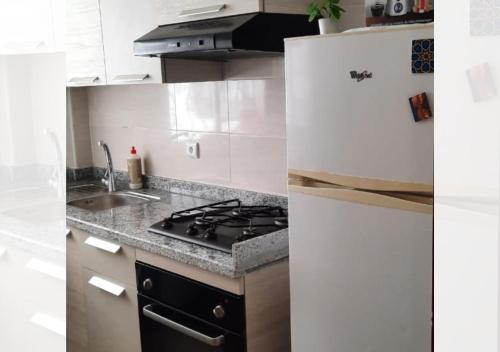 a white kitchen with a stove and a sink at Apartment-Sea-view-sand-relaxation in Tangier