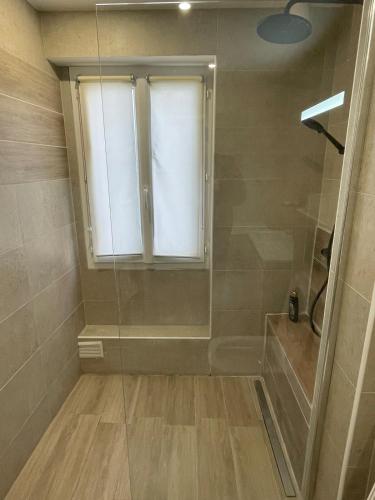 La salle de bains est pourvue d'une douche et d'une fenêtre. dans l'établissement Paris 8, perfectly located, à Paris