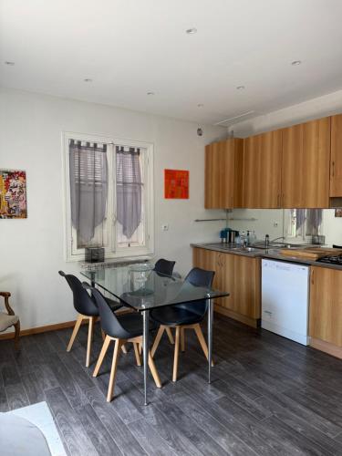 - une cuisine avec une table en verre et des chaises dans l'établissement Maison Antibes, à Antibes