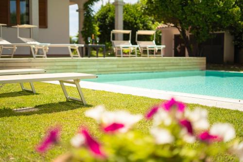 a picnic table next to a pool with chairs and flowers at Mera House in Posada