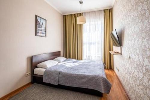 a bedroom with a bed and a large window at Апартаменти Проспект Свободи, центр міста! Класс Люкс! in Lviv