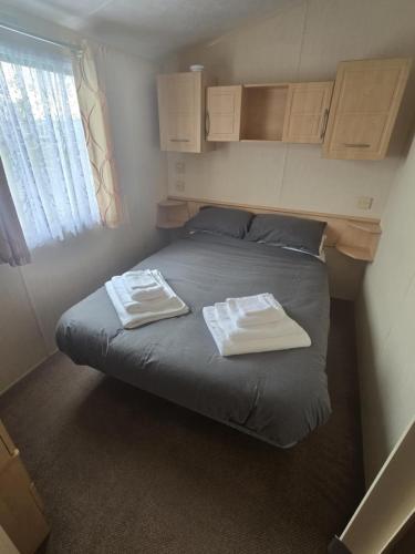 a bed in a small room with two towels on it at Chasing The Dream k52, Ingoldmells, FREE WIFI in Ingoldmells