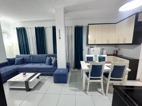 a living room with a blue couch and a table at Vila Reni Risi in Ksamil