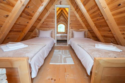 two beds in a room in a log cabin at Wolf's Peak in Babljak