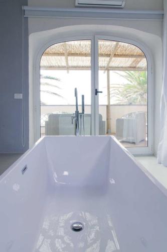 a white bath tub in a room with a window at Eremo di Montevergine Ischia Apartments in Forio d'Ischia