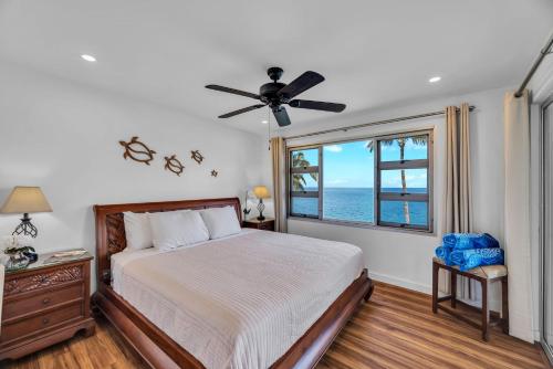 a bedroom with a bed and a window with the ocean at Watch Whales and Sunsets from your Bed - Double Master Sunset Suite in Kihei