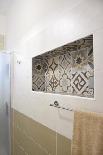 a bathroom with a shower and a tile wall at A Casuzza in Salemi