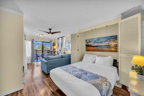 a bedroom with a bed and a blue couch at KAC201 Across from the Beach - Cozy Studio with Ocean View in Wailea