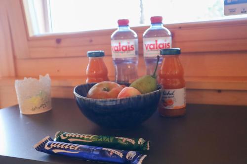 a bowl of fruit and bottles of juice on a table at Chalet Tzarbonire in Chalais