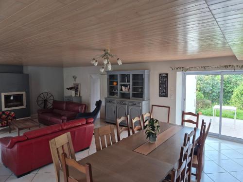 une salle à manger et un salon avec une table et des chaises dans l'établissement Gîte Ô Pré'Vert, à Le Poiré-sur-Vie