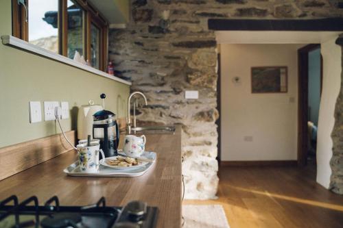 a kitchen counter with a plate of food on it at Cosy Underfloor Heated 17th Century Renovated Mill with Stunning Views - Ty Felin in Beddgelert