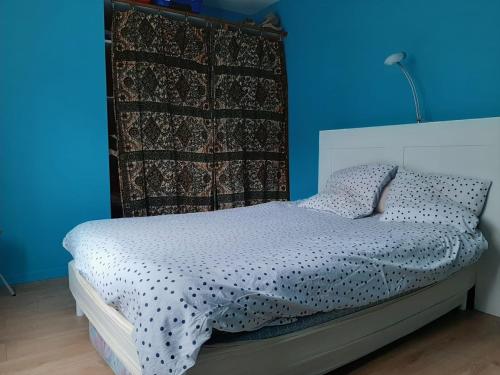 une chambre avec un lit avec un mur bleu dans l'établissement Lepin House, à Lazer