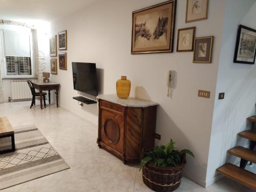 a living room with a tv and a vase on a cabinet at Appartameno Calnova in Vodnjan