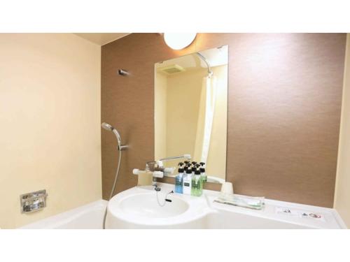 a bathroom with a sink and a mirror at Urban Hotel Kyoto - Vacation STAY 87384v in Kyoto