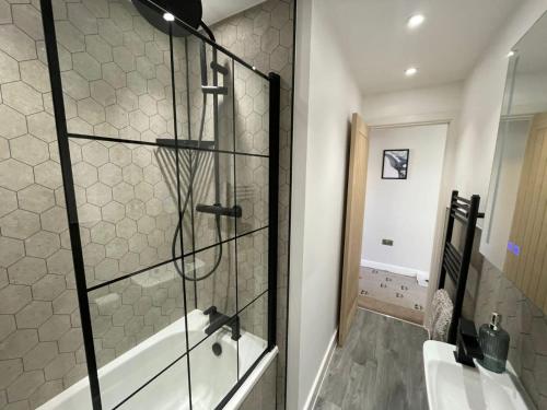 a bathroom with a tub and a glass shower at Stunning 4-Bedroom Home Sleeps 6 in Thornton Heath