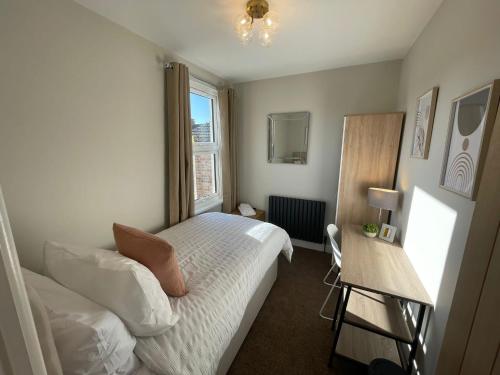 a small bedroom with a bed and a window at Stunning 4-Bedroom Home Sleeps 6 in Thornton Heath