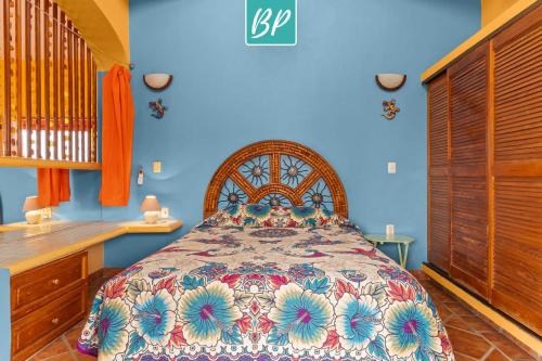 a bedroom with a bed and a blue wall at Casa Rodeo - Golden Zone Villa with Large Pool & Rooftop Ocean Views in Bucerías