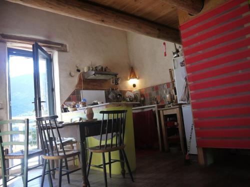 une cuisine avec une table, des chaises et un comptoir dans l'établissement Muko House, à Montmeyan