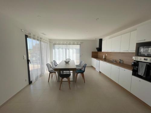une cuisine avec une table et des chaises dans une pièce dans l'établissement Villa 3 chambres proche plage, à Portiragnes