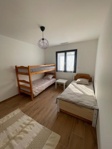 une chambre avec deux lits et un lit superposé dans l'établissement Villa 3 chambres proche plage, à Portiragnes