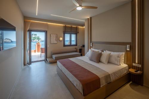a bedroom with a large bed and a balcony at Parga Harbor Suites in Parga