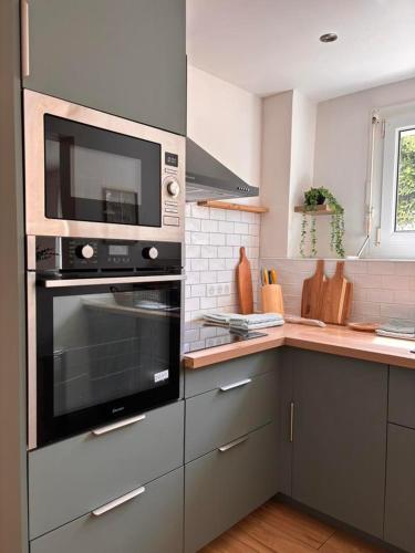 une cuisine avec une cuisinière et un micro-ondes dans l'établissement Maison de vacances, à Saint-Laurent-de-la-Salanque