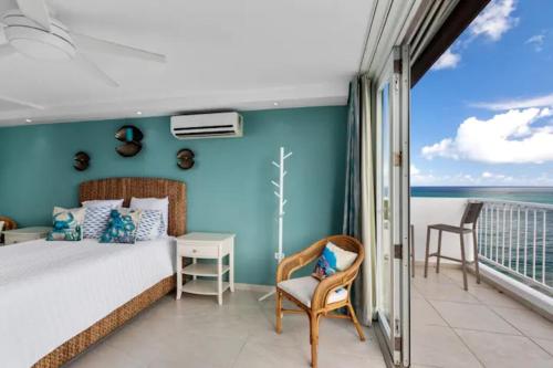 サンファンにあるBeachfront Retreat-Panoramic Sunrise Views-1 Parking Spotのベッドルーム1室(ベッド1台付)、海を望むバルコニーが備わります。