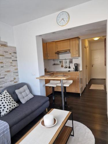 un salon avec un canapé et une cuisine dans l'établissement Bright apartment 10 minutes from Cannes, au Cannet