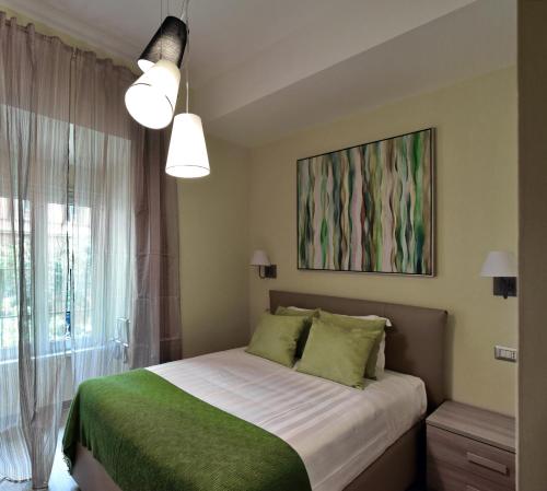 a bedroom with a bed with green sheets and a window at CdR Guest House in Rome