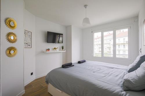 une chambre blanche avec un lit et une fenêtre dans l'établissement T2 rénové hyper centre vue dégagée, à Grenoble