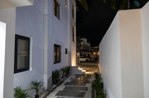 a hallway of a white building at night at Rooftop Couples Suites at Ocean Park Beach Club in San Juan