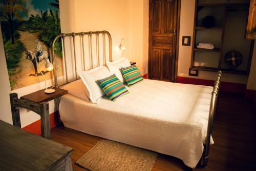 a bedroom with a bed with green and white pillows at Finca La Manchuria in Salgar