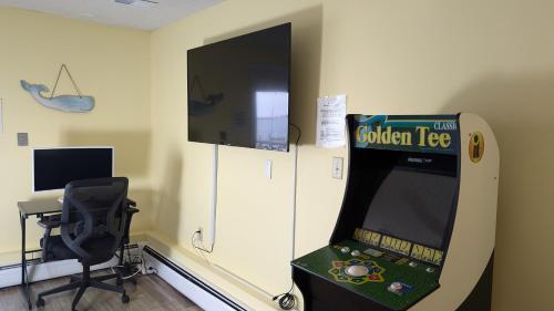 a room with a video game machine and a chair at Bay Front Home - Watch the sun rise over LBI. Pier for Boat/Swim/SUP/Kayak/Crab in Manahawkin