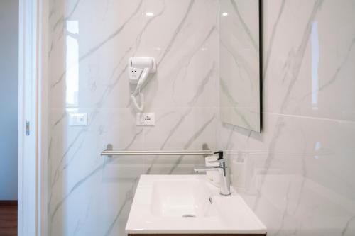 a white bathroom with a sink and a mirror at Calabreeze in Villa San Giovanni