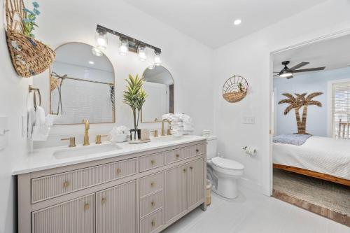 a bathroom with a sink and a mirror and a bed at Sunset Shack in Myrtle Beach