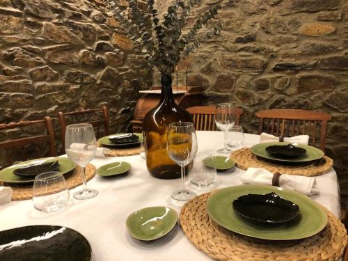 a table with green plates and glasses and a vase at Quinta do Barrocal - Casa de Campo in Peso da Régua