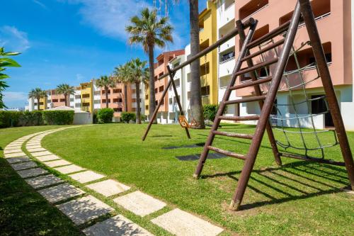 a swing set in a park next to a building at Bellavista Avenida By BeGuest in Albufeira