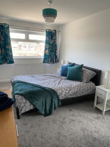 a bedroom with a bed with blue pillows and a window at Haven Vale in Stockton-on-Tees
