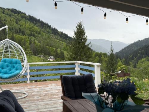 a porch with a swing and a chair on a deck at Садиба "Ековид" in Krivorovnya