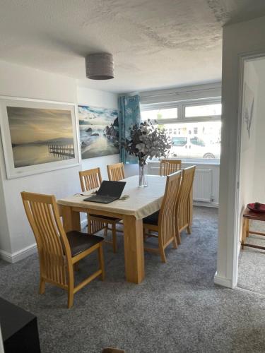 a dining room with a table with chairs and a laptop at Haven Vale in Stockton-on-Tees